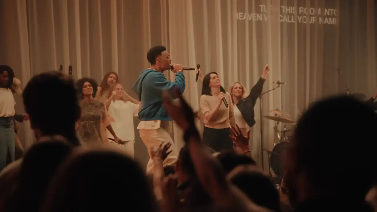 Tauren Wells singing under warm overhead light during Making Room