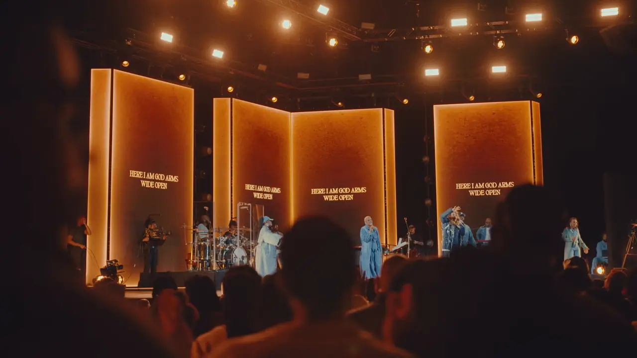 Amber and pink look across the panels with the band and singers in front